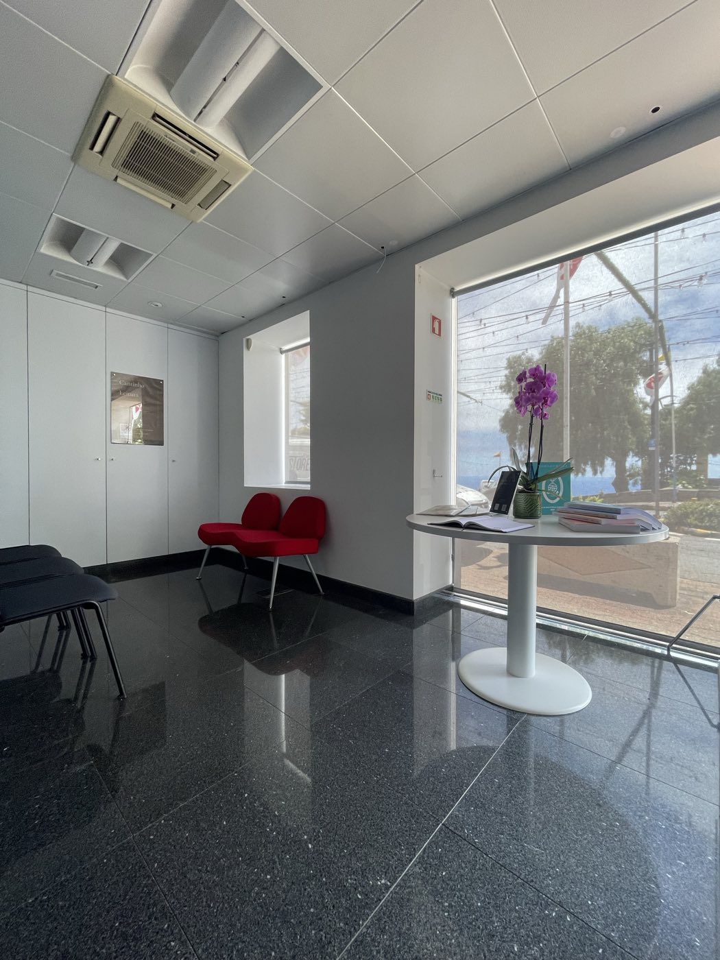 Receção da Arco Fiscal, com mesa de atendimento e vista de mar